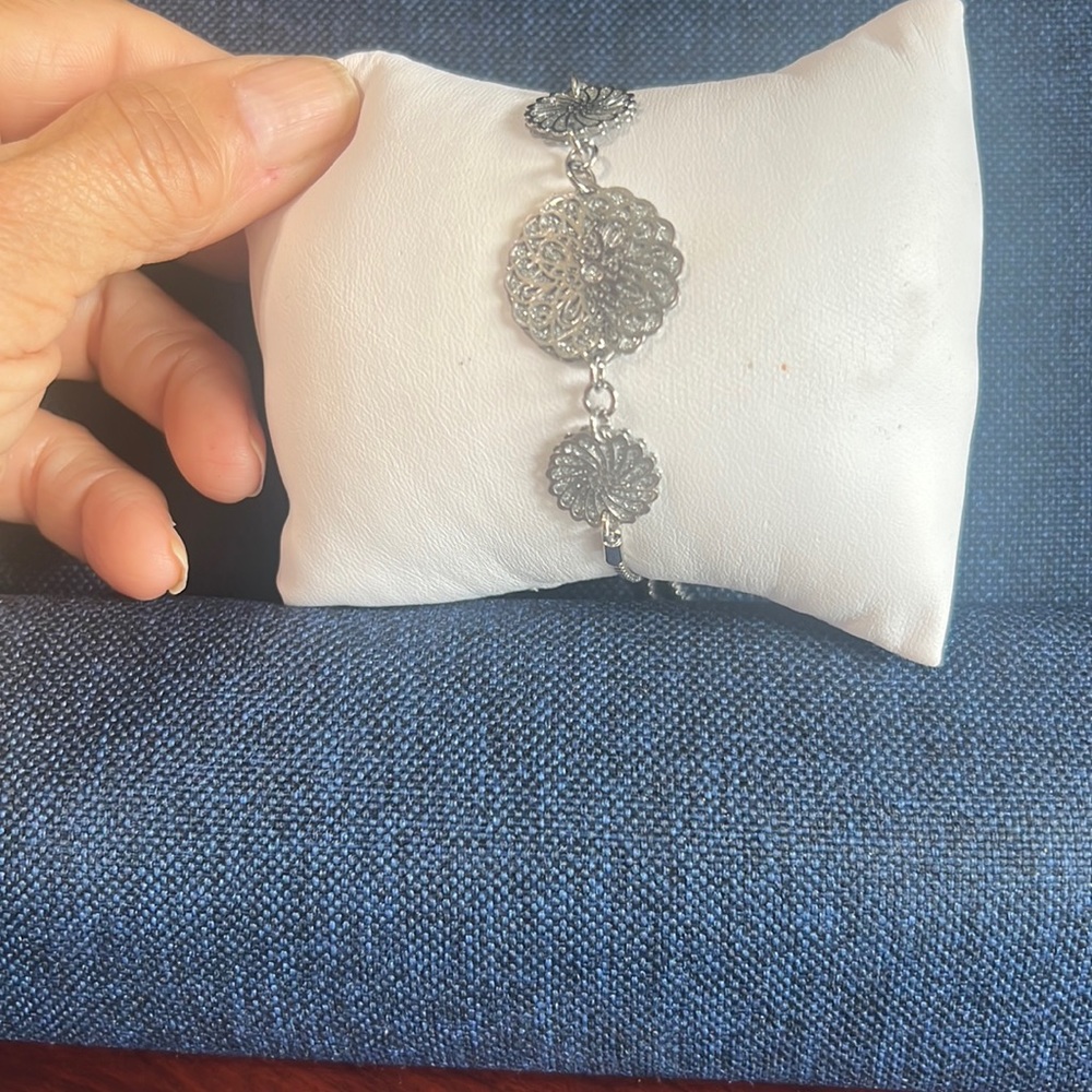 Silver adjustable bracelet with three flower design in the top